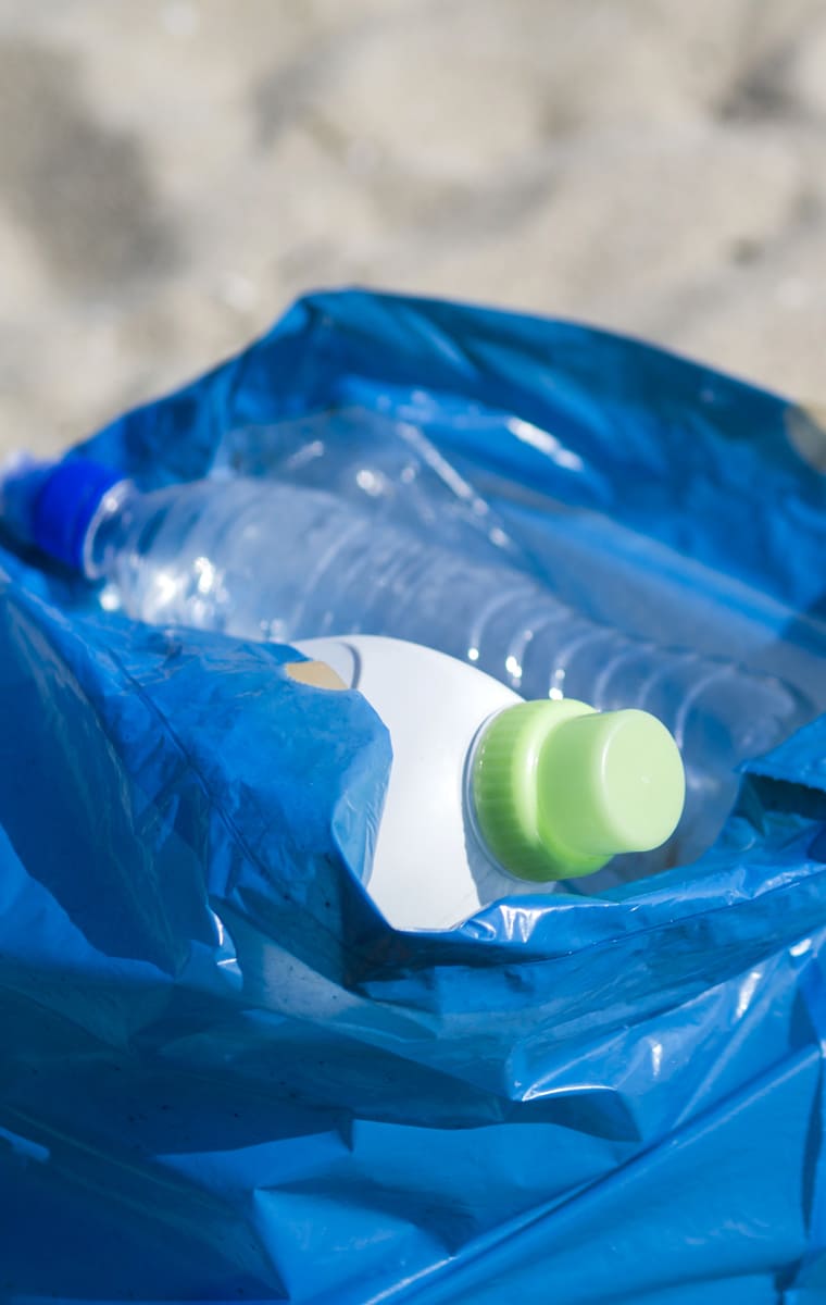 Déchets contenus dans un sac posé sur le sable