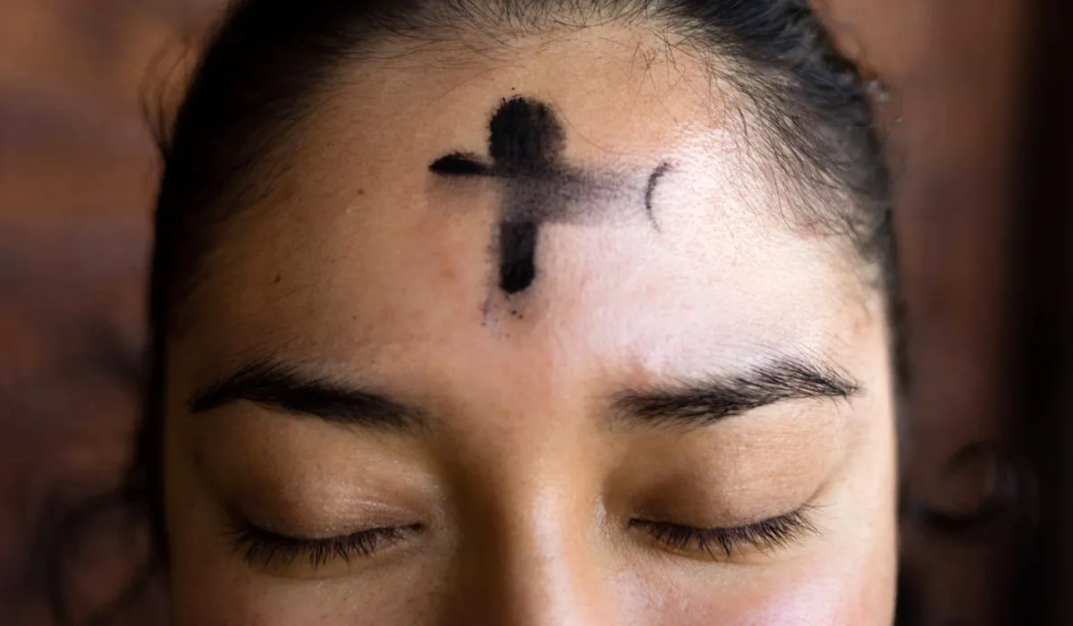 Cross of ashes on a faithful woman's forehead